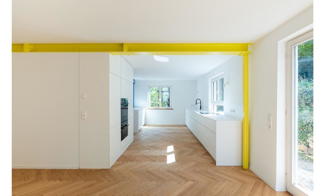 . . . sorgt jetzt der schwefelgelbe Stahlträger  für eine gelungene Zonierung des offenen Grundrisses im Wohn- und Küchenbereich.