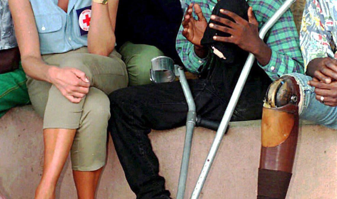 1997 hört Diana bei einem Besuch in einer orthopädischen Klinik in Luanda, Angola, ehemaligen Soldaten zu, die während des 20-jährigen Bürgerkriegs Opfer von Landminenexplosionen geworden sind.