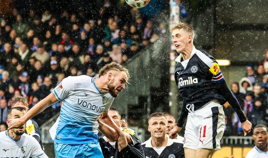 2. Liga in Kiel: Bernhardsson (r, Kiel) und Strompf (Bochum) kämpfen bei Regen um jeden Ball.