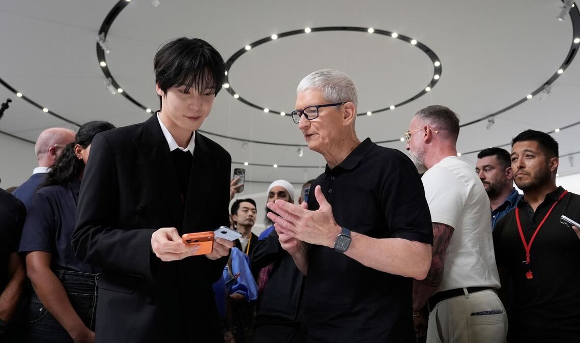 2026: Apple Chef Tim Cook (M) steht unter Druck, ein neues großes Ding - "One More Thing" abzuliefern.