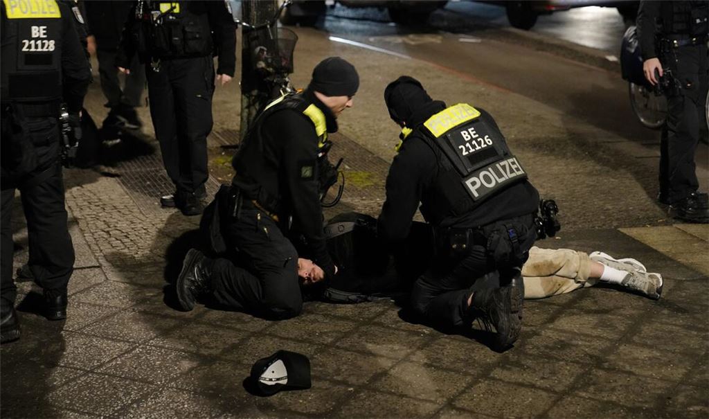 21.02.2025, Berlin: Polizeibeamte halten einen Mann am Holocaust-Mahnmal fest, nachdem ein anderer Mann schwer verletzt wurde.