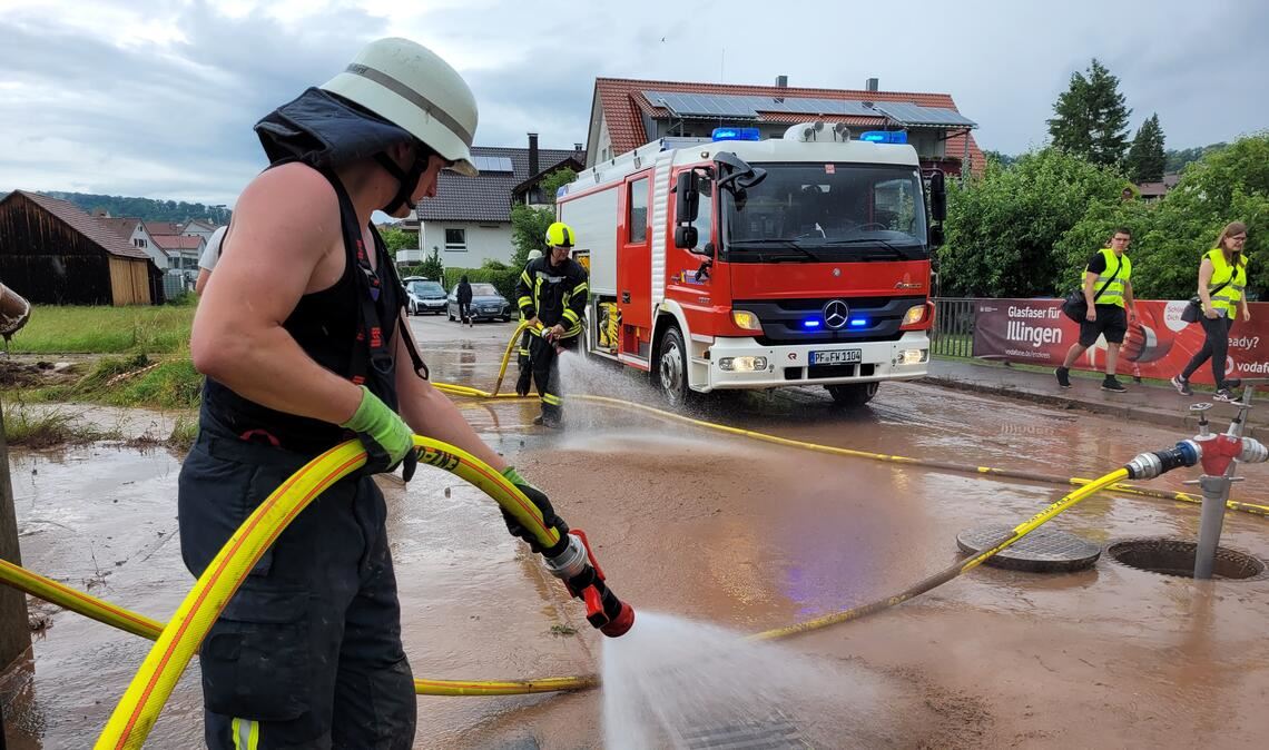 5. Juni 2022: Nachdem sich ein Gewitter entladen hat, spült die Feuerwehr den Schlamm von der Hauptstraße in Schützingen. Foto: Hansen