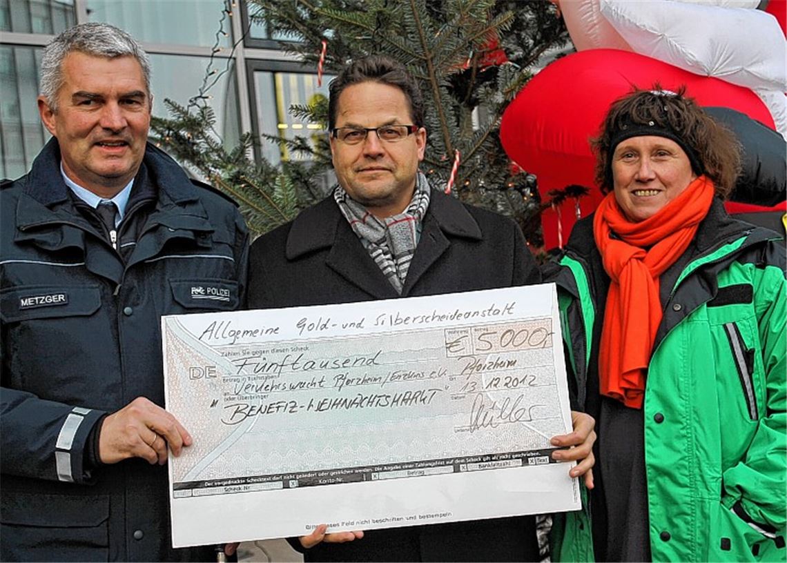 5000 Euro für die neue Jugendverkehrsschule in Pforzheim: Polizeichef Burkhard Metzger (li.) und die Vorsitzende der Verkehrswacht Pforzheim/Enzkreis, Daniela Vogel, freuen sich über die Spende, die Oliver Müller von der Allgemeinen Gold- und Silberscheideanstalt überreicht.