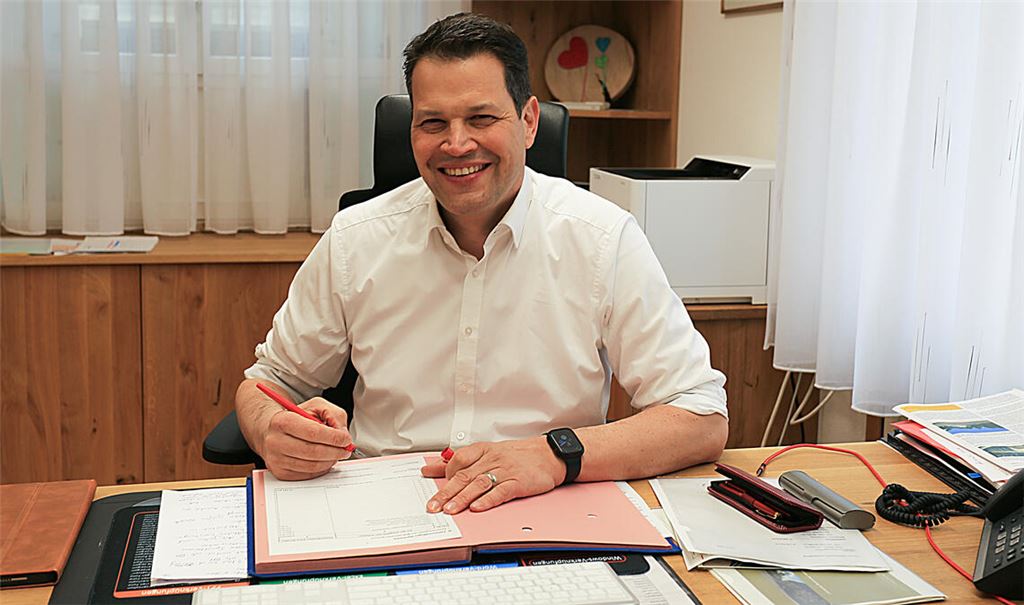 Aaron Treut an seinem Schreibtisch im Maulbronner Rathaus. Der 50-Jährige betont, dass sein Amt auch nach 1001 Tagen nach wie vor sein „Traumjob“ sei. Foto: Fegert/Stadt Maulbronn