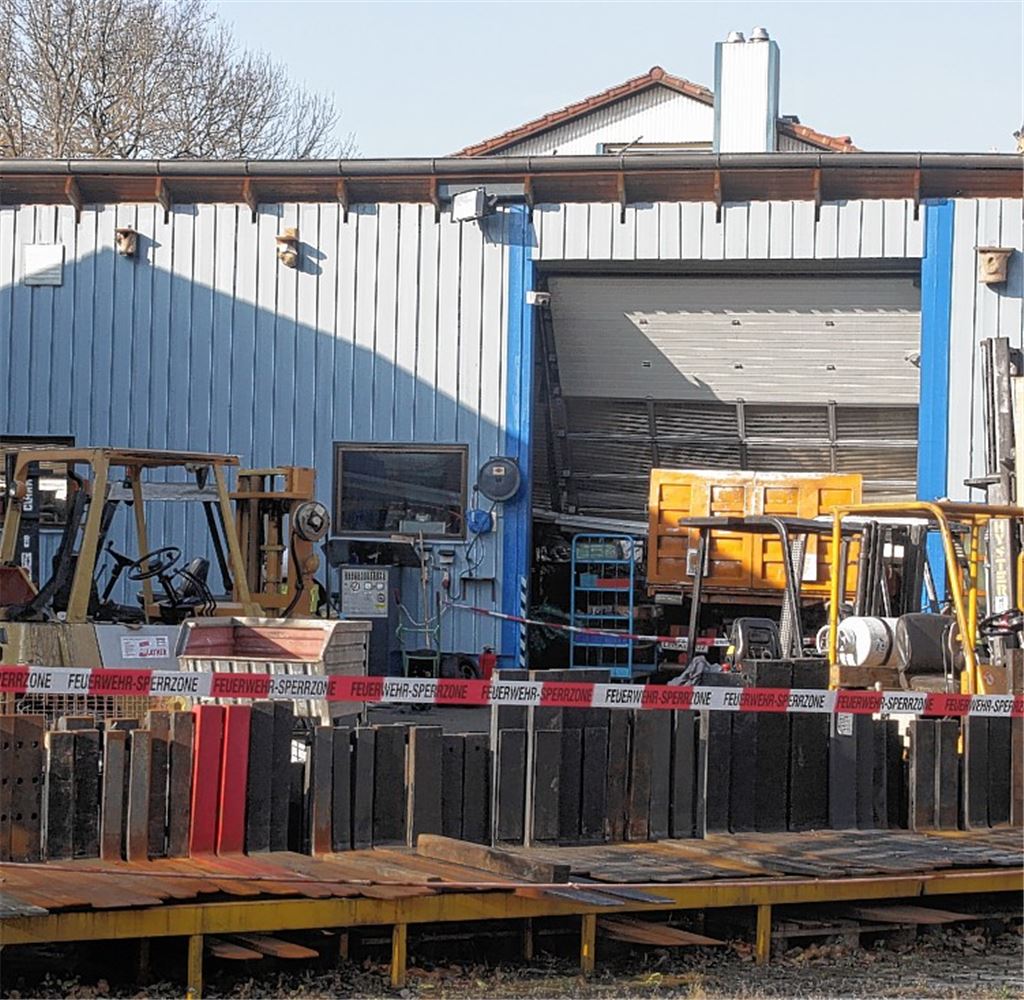 Abgesperrt: im Hintergrund die vom Feuer betroffene Firmenhalle, in der als Folge der Hitzeentwicklung das Dach eingestürzt ist und unter anderem einen Lastwagen unter sich begraben hat