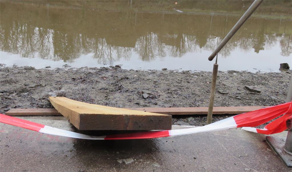 Absperrband, Schlamm, aber deutlich mehr als eine Pfütze auf dem Grund: Weil zunächst nicht alle Fische entnommen werden konnten, wurde wieder Wasser eingelassen. Foto: Becker