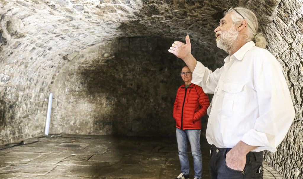 Achim Händle vom Heimatverein Lomersheim (re.) stellt bei der Einweihungsfeier den sanierten historischen Bierkeller vor – aus Sicht der Stadtverwaltung ein Beispiel dafür, wie Ehrenamt und finanzielle Förderung durch die öffentliche Hand erfolgreich zusammenspielen können. Foto: Archiv