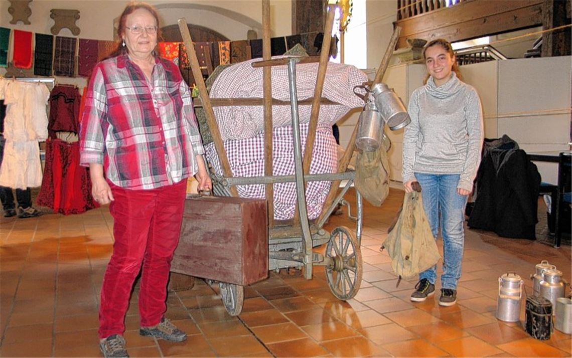 Adelheid Teschner (li.) und Maia Di Rosa Reichrath präsentieren einen Wagen, wie er auf den Flüchtlingstrecks zum Einsatz kam, und Gegenstände, die teils unter Lebensgefahr gerettet wurden.