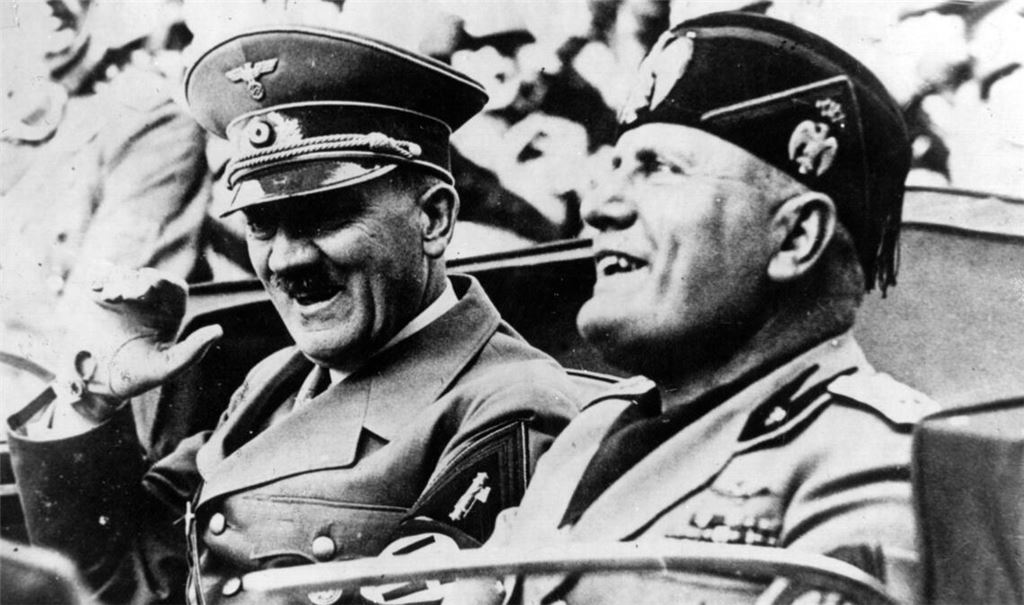 Adolf Hitler (li.) und der italienische Ministerpräsident und Duce Benito Mussolini (re.) fahren in einem offenen Wagen durch Florenz. Der Italien-Besuch des NS-Diktators vom 3. bis zum 9. Mai 1938 wurde zu einer Machtdemonstration des Faschismus.