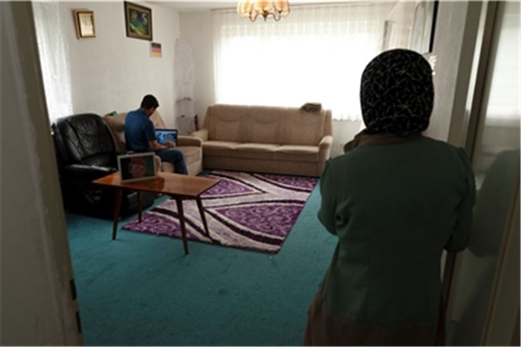 Afghanische Familie in ihrer Mühlacker Wohnung – an der Wand die Farben der Deutschlandflagge. Übers Internet informieren sie sich über die Vorgänge in ihrer Heimat. Foto: Fotomoment