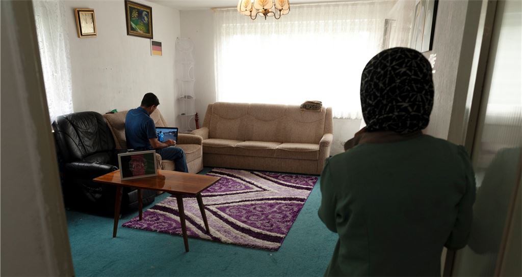 Afghanische Familie in ihrer Mühlacker Wohnung – an der Wand die Farben der Deutschlandflagge. Übers Internet informieren sie sich über die Vorgänge in ihrer Heimat.Foto: Fotomoment