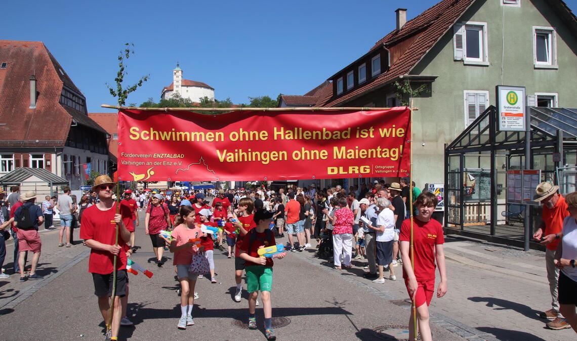 Aktuelle kommunalpolitische Botschaft beim Festumzug zum „Maientag“: Die DLRG wirbt für den Erhalt des Enztalbades. Foto: Arning