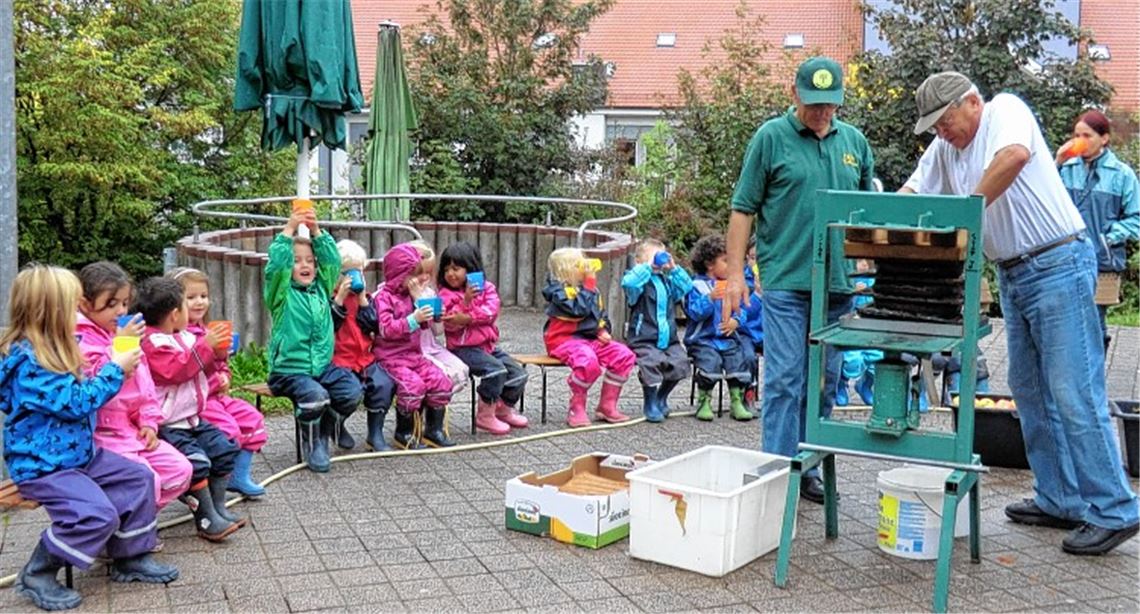 Albrecht Straub und Stefan Neuberger helfen beim Apfelsaftpressen. Foto: privat