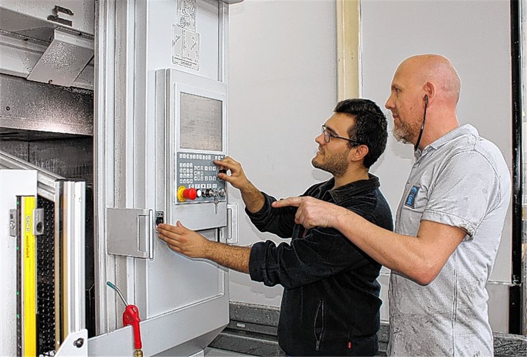 Alejandro Melgarejo (li. mit dem stellvertretenden Abteilungsleiter Hans-Jürgen Bieber) an seinem Arbeitsplatz bei der Firma Abele.