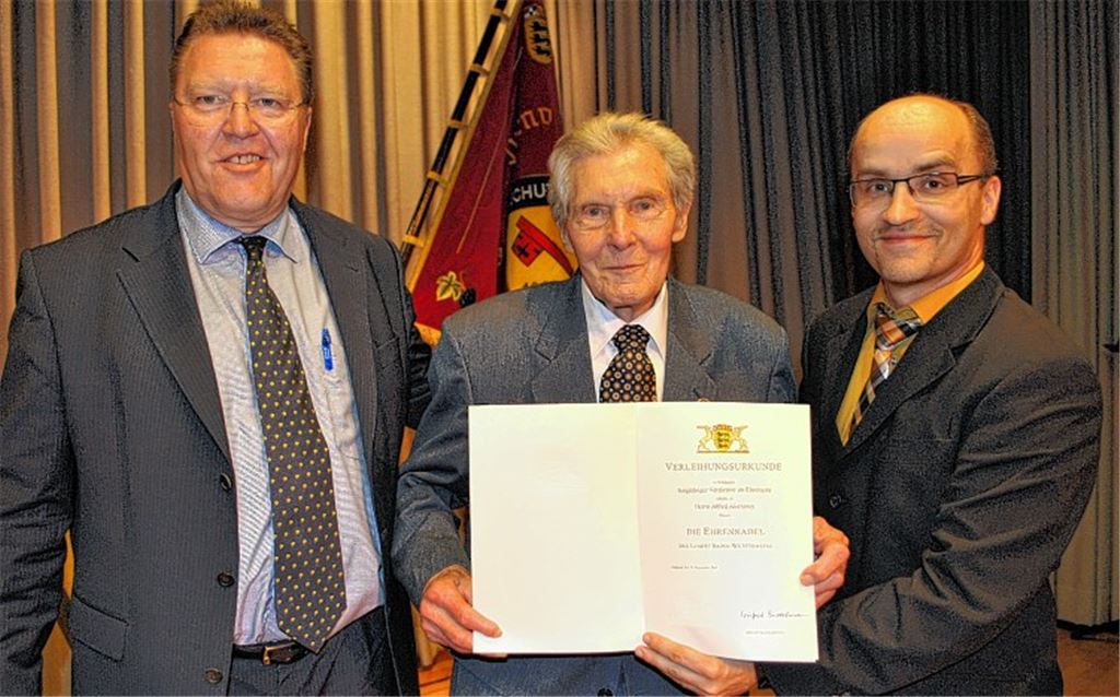 Alfred Aisenbrey (Mitte, mit dem TVS-Vorsitzenden Bernd Schaßberger, li., und Bürgermeister Harald Eiberger) erhält die höchste Auszeichnung, die das Land Baden-Württemberg zu vergeben hat.
