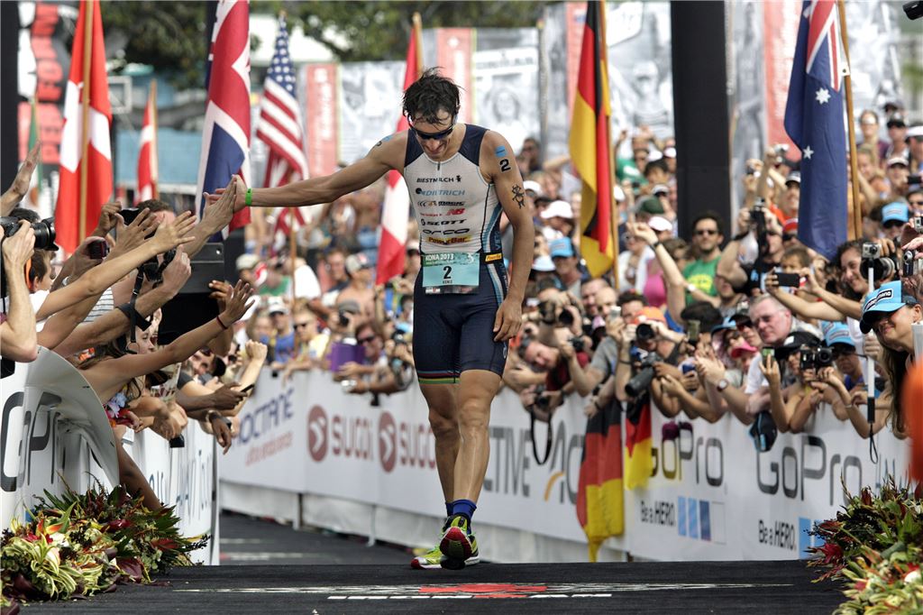 Alles nicht geträumt: Sebastian Kienle klatscht abgekämpft, aber überglücklich auf der Zielgeraden in Kona die Zuschauer ab. „Die Beine tun weh, aber das ist angenehm“, sagt er zwei Tage später.   Foto: AP