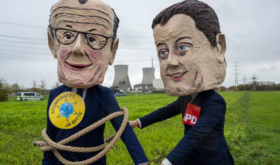 Als Bundeskanzler Friedrich Merz (l) und SPD-Vorsitzender Lars Klingbeil verkleidete Atomkraftbefürworter demonstrieren gegen die Sprengung.
