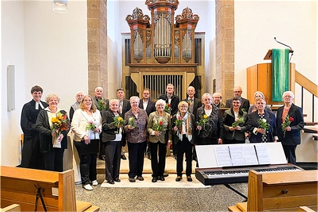 Als Dankeschön zum Jubiläum überreicht Pfarrer Lukas Lorbeer Blumen an die Chormitglieder. Foto: Common