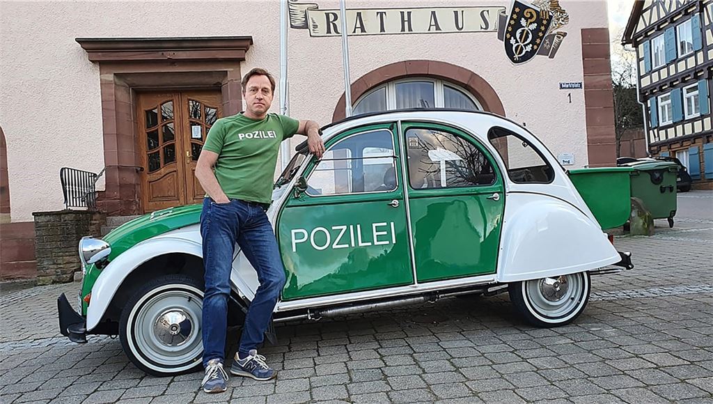 Als Gründer der Dorf-AG weiter satirisch aktiv: Der Dorfschelm in voller Montur mit seinem selbsterklärten „Dienstauto“ vor dem Rathaus. Foto: privat