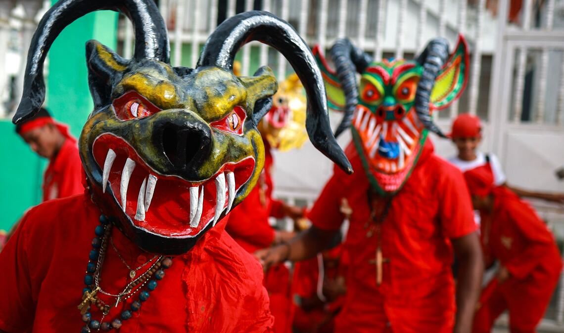 Als Teufel verkleidete Männer nehmen in Venezuela an einem traditionellen Volksfest zu Fronleichnam teil.