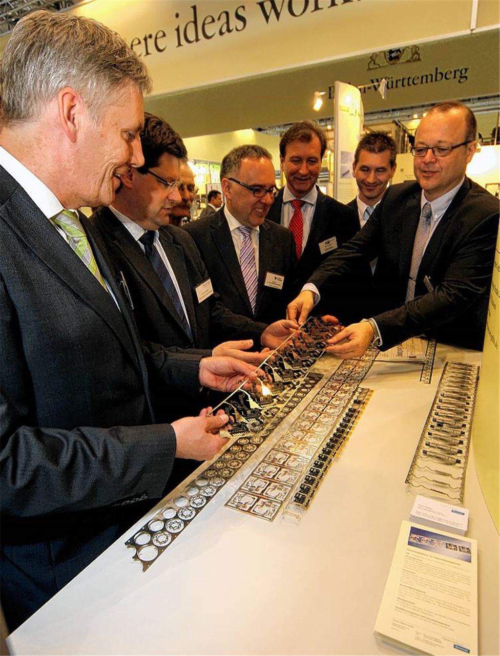 Am Stand von Kummer-Stanztechnik aus Ötisheim erläutert Vertriebsleiter Ulrich Hornung (re.) den Akteuren der regionalen Wirtschaftsförderung (v.li.) Landrat Helmut Riegger (Calw), Oberbürgermeister Julian Oswald (Freudenstadt), Landrat Klaus Michael Rückert (Freudenstadt), IHK-Hauptgeschäftsführer Martin Keppler sowie Enzkreis-Finanzdezernent Frank Stephan die Fertigungstiefe des Spezialisten für Stanz- und Kunststofftechnik.