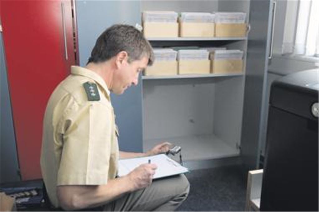 Am Tatort: Polizeihauptkommissar Uwe Mörgenthaler vor der Lücke im Regal, wo zuvor ein Tresor stand. Bei einem Einbruch ins Sekretariat der Verbandsschule Platte haben bislang unbekannte Täter den Safe mit Brachialgewalt aus seiner Verankerung gerissen und durch ein Fenster ins Freie gehievt. Es handelt sich um den zweiten Einbruch in die Schule innerhalb weniger Wochen. 
Foto: Franz