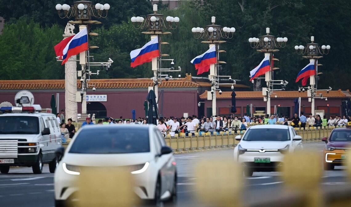 Am Tiananmen Platz rollt der Verkehr an russischen Fahnen vorbei.