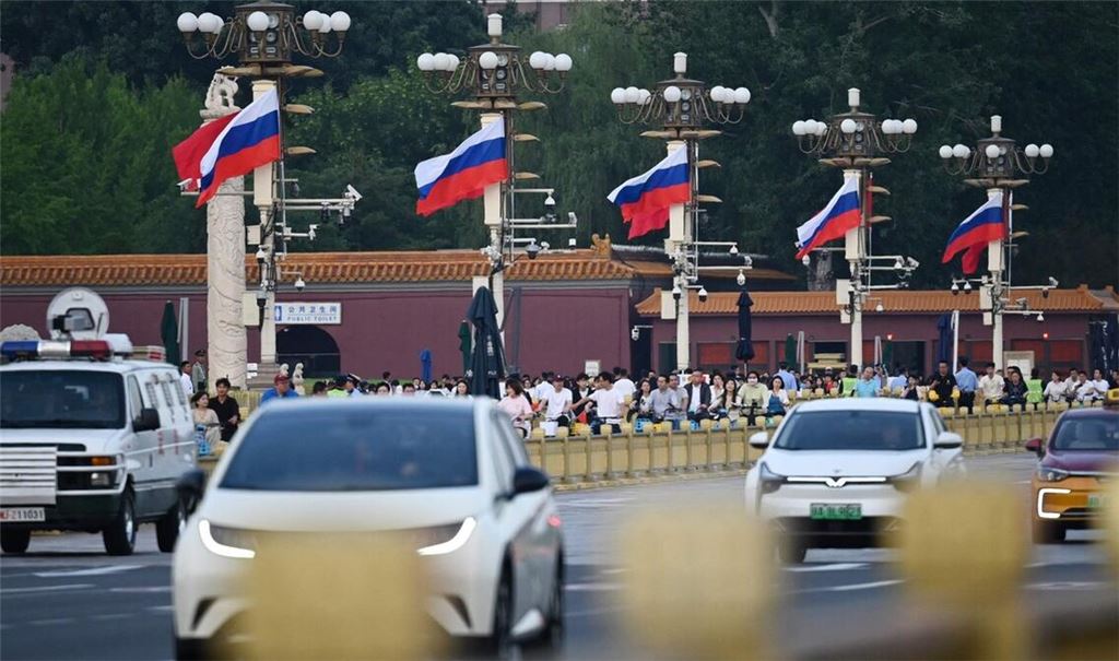 Am Tiananmen Platz rollt der Verkehr an russischen Fahnen vorbei.