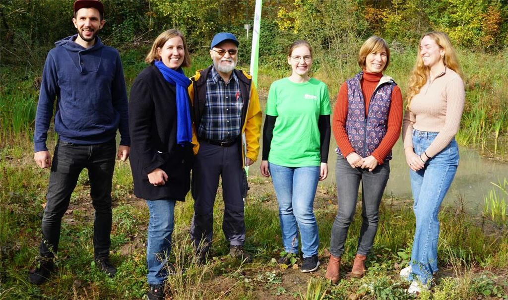 Am sanierten Tümpel: Michael Hudak (v.li.), Vorsitzender der BUND-Ortsgruppe Mühlacker, Dr. Hilde Neidhardt, Erste Landesbeamtin des Enzkreises, Hermann Seufer, Regionalbetreuer des ABS (Amphibien & Reptilien Biotopschutz in Baden- Württemberg), Sarah Christmann, Master Biologie und Projektleitung, Inga Schraud, Geschäftsführerin Landschaftserhaltungsverband Enzkreis und Nena Raabe vom Landschaftserhaltungsverband Enzkreis. Bild rechts: Inga Schraud mit einem Foto der bedrohten Erdkröte. Fotos: Bastian