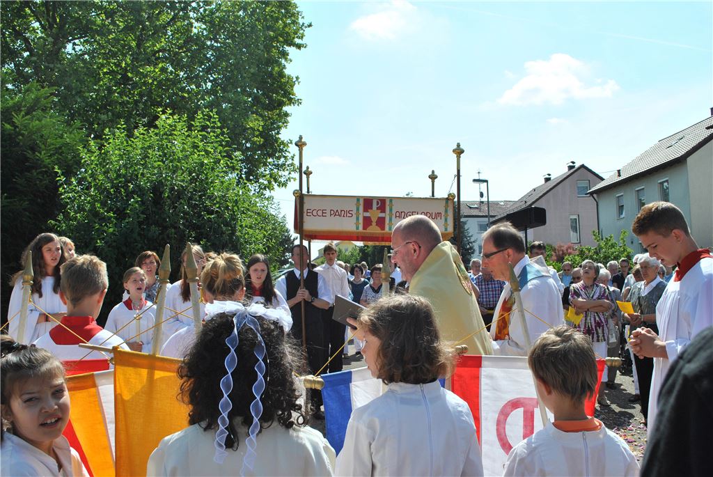An drei Stationen macht die Fronleichnams-Prozession Halt. Die Kommunionskinder führen den Prozessionszug an. Dekan Claus Schmidt (Mitte) trägt die Monstranz mit der Hostie. Foto: Stahlfeld