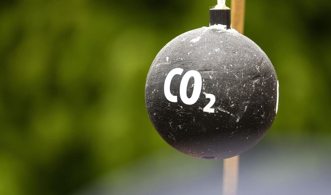 An einem Stab hängt vor Beginn einer Demonstration in Sachsen symbolisch eine "CO2-Bombe".
