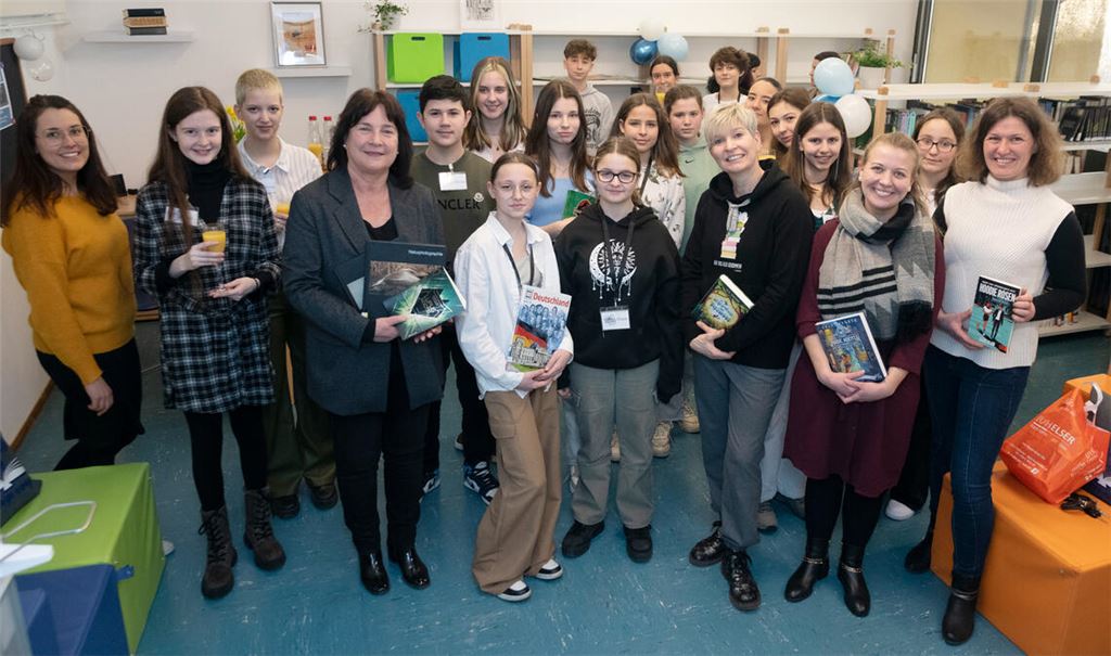 Andrea Maisel (4. von li.), Andrea Förster (3. von re. vorne) weihen mit Schülerinnen und Schülern sowie Lehrkräften die neue Schulbücherei ein. Foto: Fotomoment