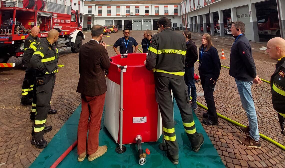 Angehörige der Feuerwehr von Reggio stellen ein mobiles Wasserbecken vor, das bei der Waldbrandbekämpfung zum Einsatz kommt. Foto: E35, Giulia Semeghini