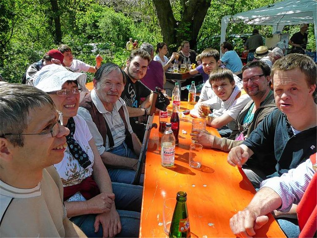 Angehörige der Lebenshilfe treffen sich nach einer Wanderung vor der Weidachhütte in Mühlhausen.