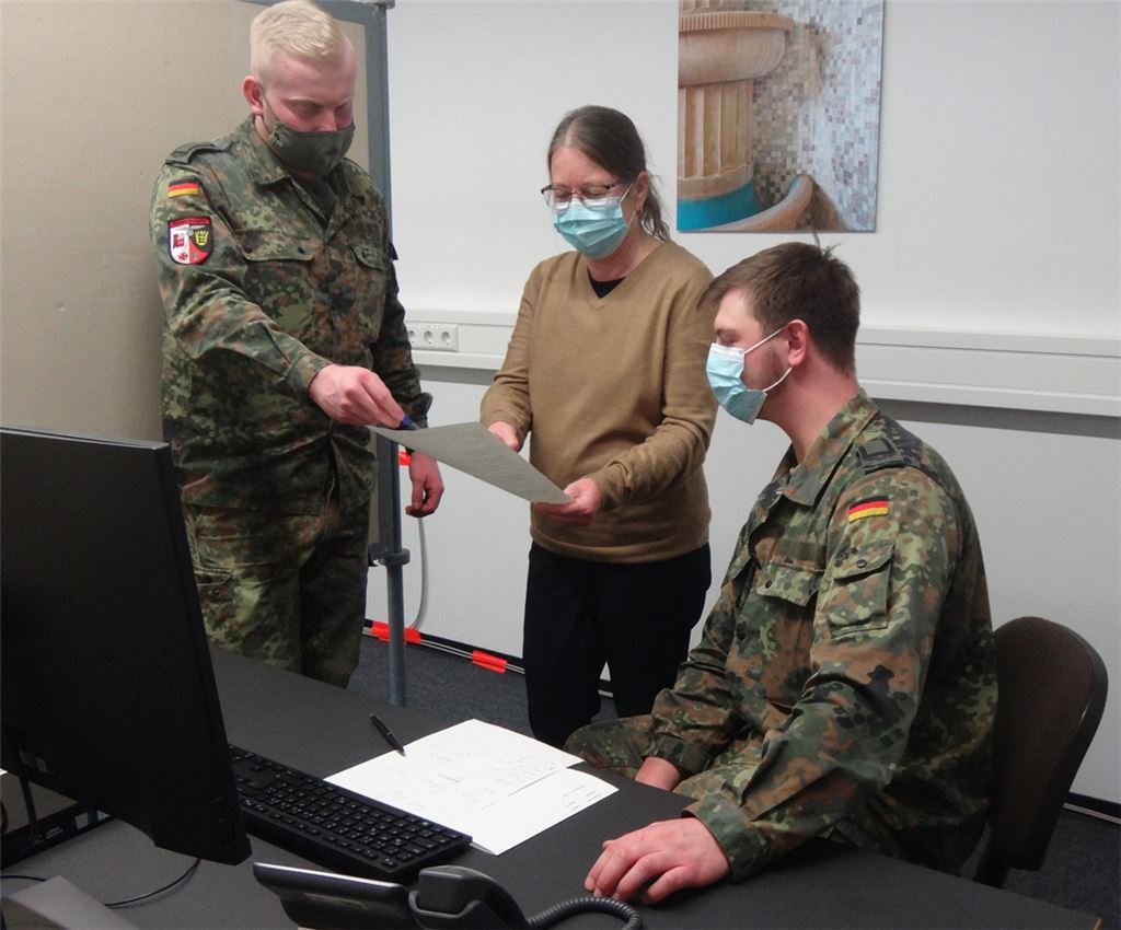 Angelika Edwards, stellvertretende Leiterin des Gesundheitsamts, bespricht mit zwei Bundeswehr-Soldaten den nächsten Fall. Klupik