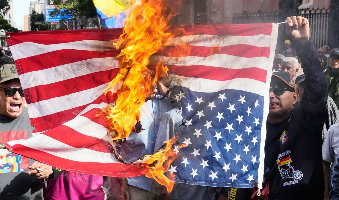 Anhänger der Regierung verbrennen eine US-Flagge in Caracas, nachdem US-Präsident Trump bekannt gegeben hatte, dass die US-Streitkräfte den venezolanischen Präsidenten Maduro und seine Frau gefangen genommen haben.