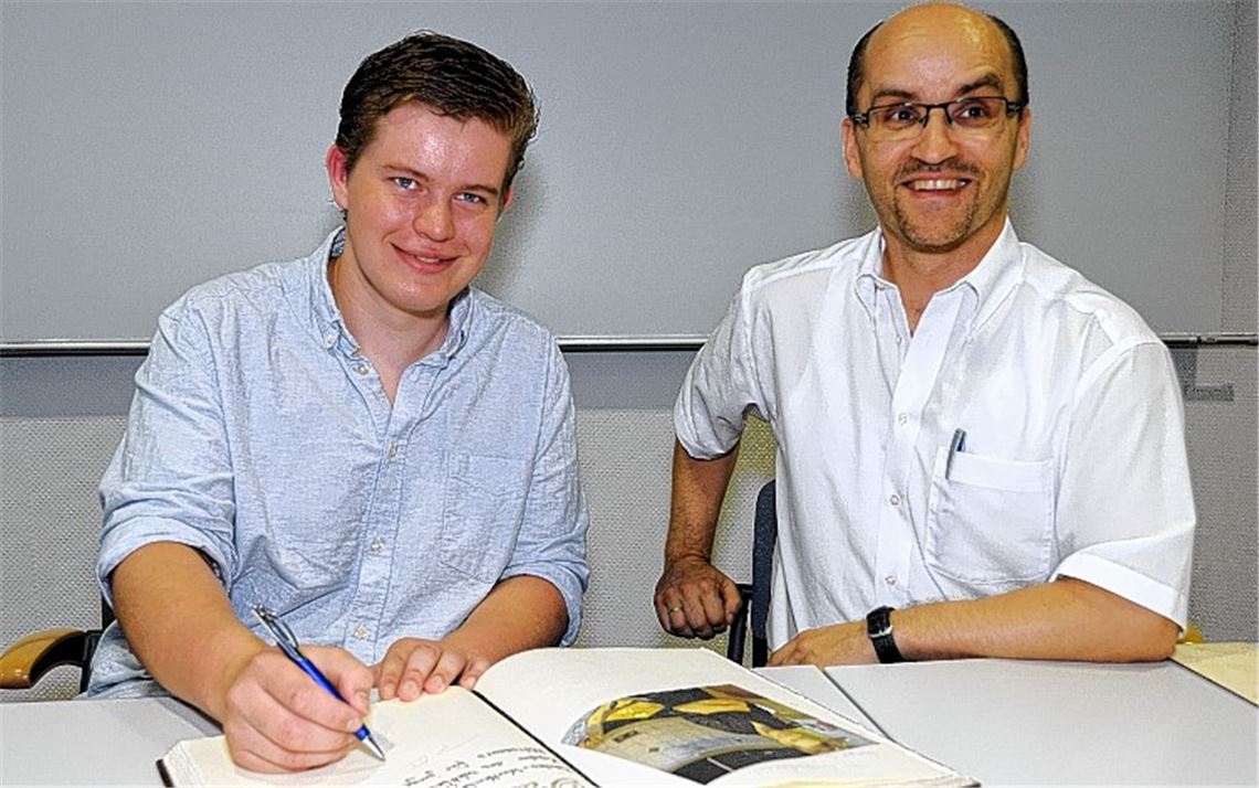 Anlässlich seines Gewinns der Deutschen Meisterschaft in einem Wettbewerb von Jungköchen trägt sich Patrick Kühn (li.) auf Einladung von Bürgermeister Harald Eiberger ins Goldene Buch der Gemeinde ein. Foto: Fotomoment