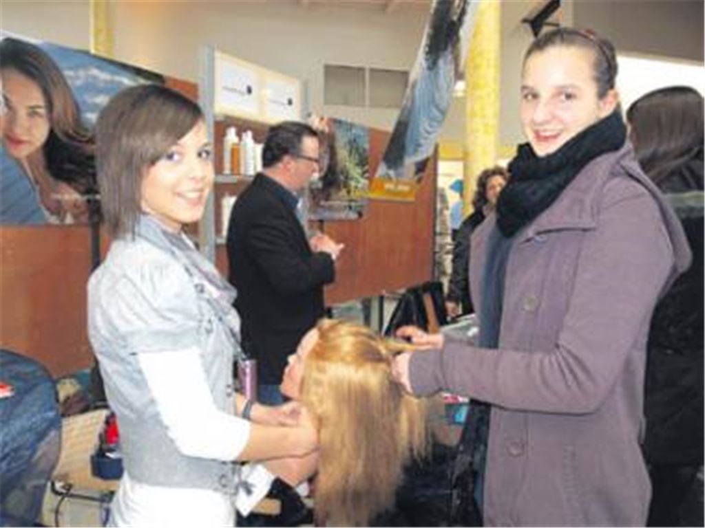 Anschaulich: Die Auszubildende im Friseurhandwerk Annika Meiser (li.) demonstriert den Besuchern in der Faust-Schule, wie gekonnt Zöpfchen geflochten werden. 