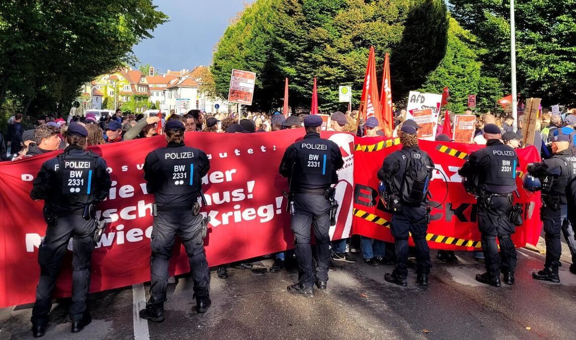 Antifa und Polizei stehen neben der Halle Auge in Auge.