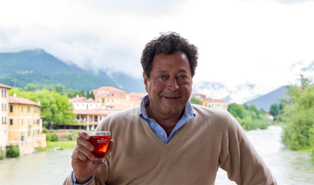 Antonio Guarda Nardini hat für die Mühlacker Veranstaltung den Rosso gestiftet. Selbst er darf nur fürs Foto mit einem Glas auf die Ponte. Seit das Wahrzeichen der Partnerstadt Bassano del Grappa 2019 Nationaldenkmal wurde, darf der Aperitif draußen nur noch im Pappbecher ausgeschenkt werden. Foto: Recken