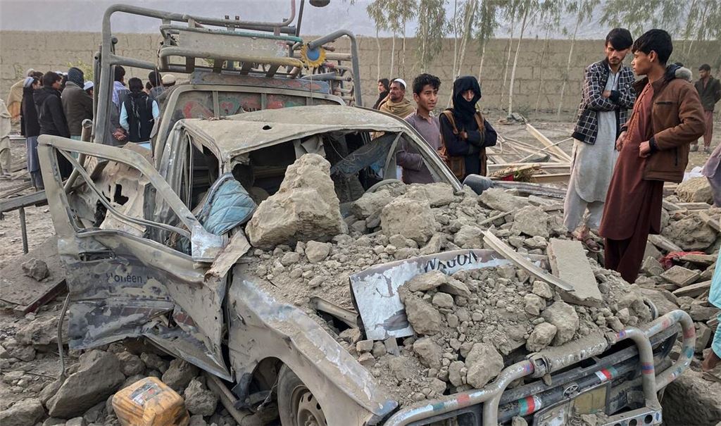 Anwohner stehen neben einem beschädigten Auto am Ort eines grenzüberschreitenden Angriffs der pakistanischen Armee in der Provinz Nangarhar. (Archivbild)