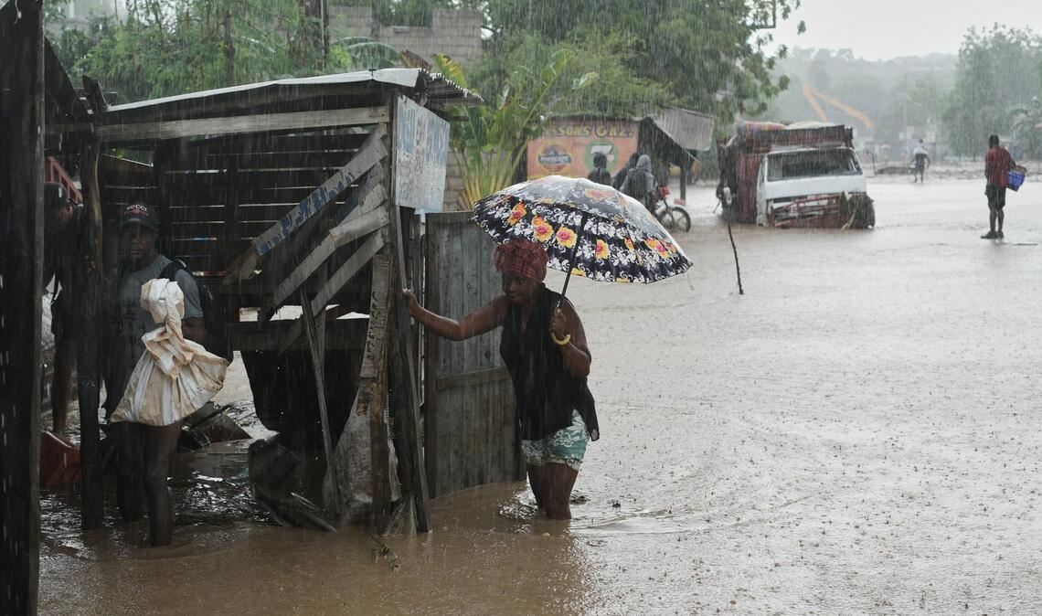 Anwohner waten durch eine überflutete Straße nach dem durchzug von Hurrikan Melissa in Petit-Goave.