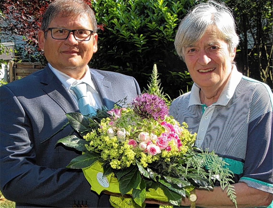 Anzeigenleiter Jochen Elmer überreicht Monika Rasp den Blumenstrauß.