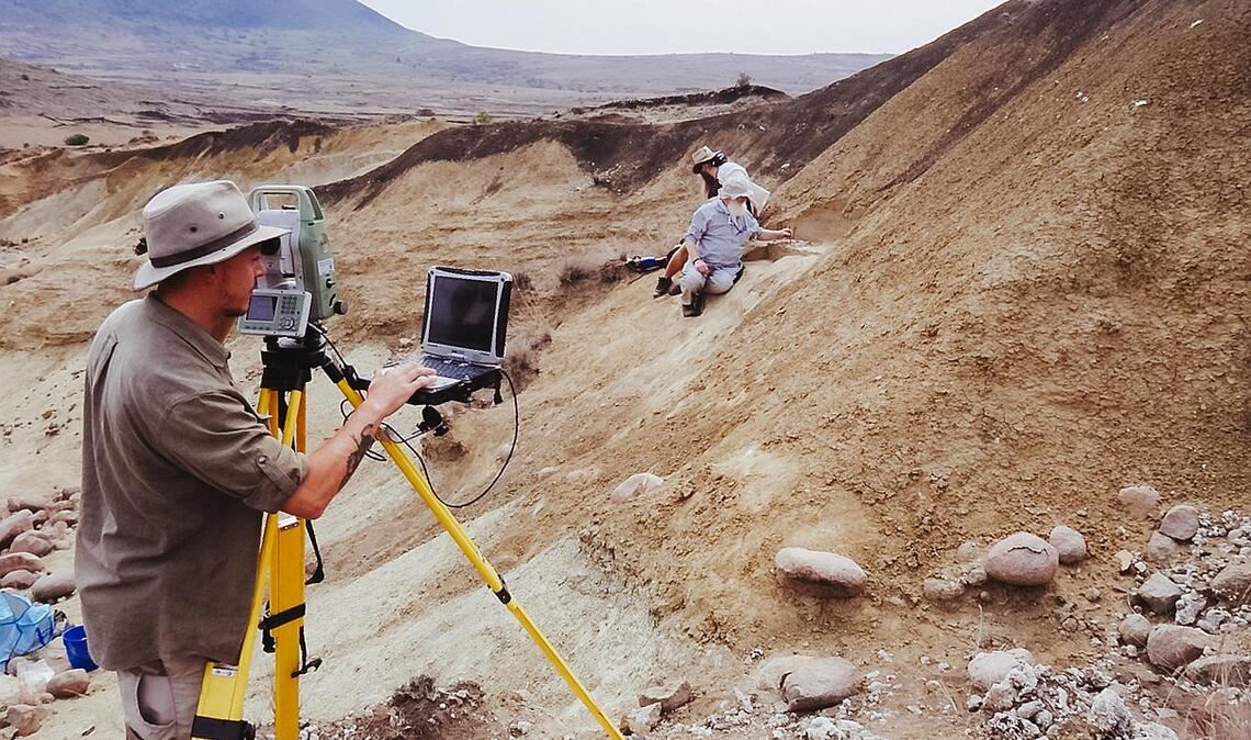 Archäologische Ausgrabungen an der Fundstelle Jojosi 6 im Jahr 2024. Die Person am Tachymeter dokumentiert die genaue räumliche Position aller gefundenen Artefakte in 3D mit einem Laser.