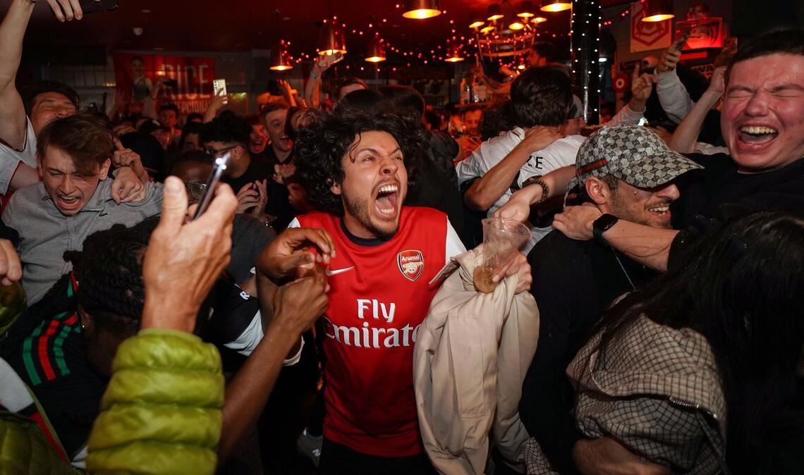 Arsenal-Anhänger feiern in einem Pub in der Nähe des Arsenal-Stadions, nachdem die Fußballmannschaft des FC Arsenal den Titel in der Premier League gewonnen hat.