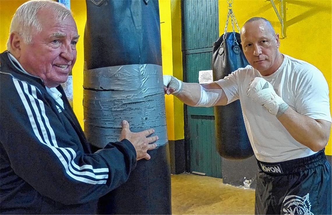 Attacke: Auch der Sandsack muss einiges aushalten, als Uwe Hück (re.) unter Anleitung von Startrainer Ulli Wegner die ersten Hiebe setzt. Foto: Roth