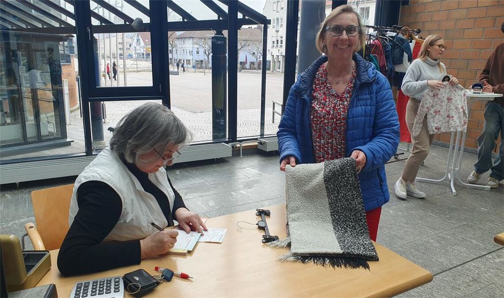 Auch ein Schal wechselt im Rathausfoyer die Besitzerin. Ulrike Gutmann-von-Langsdorff (li,), die Leiterin des Fundbüros, muss den Käufern detaillierte Quittungen ausstellen. Foto: Schröder
