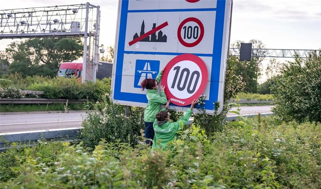 Auf Autobahnen gilt ... ein Tempo-100-Tempolimit? So zumindest wollen es Greenpeace-Aktivistinnen, hier bei der Aktion am Montagmorgen in Aachen.