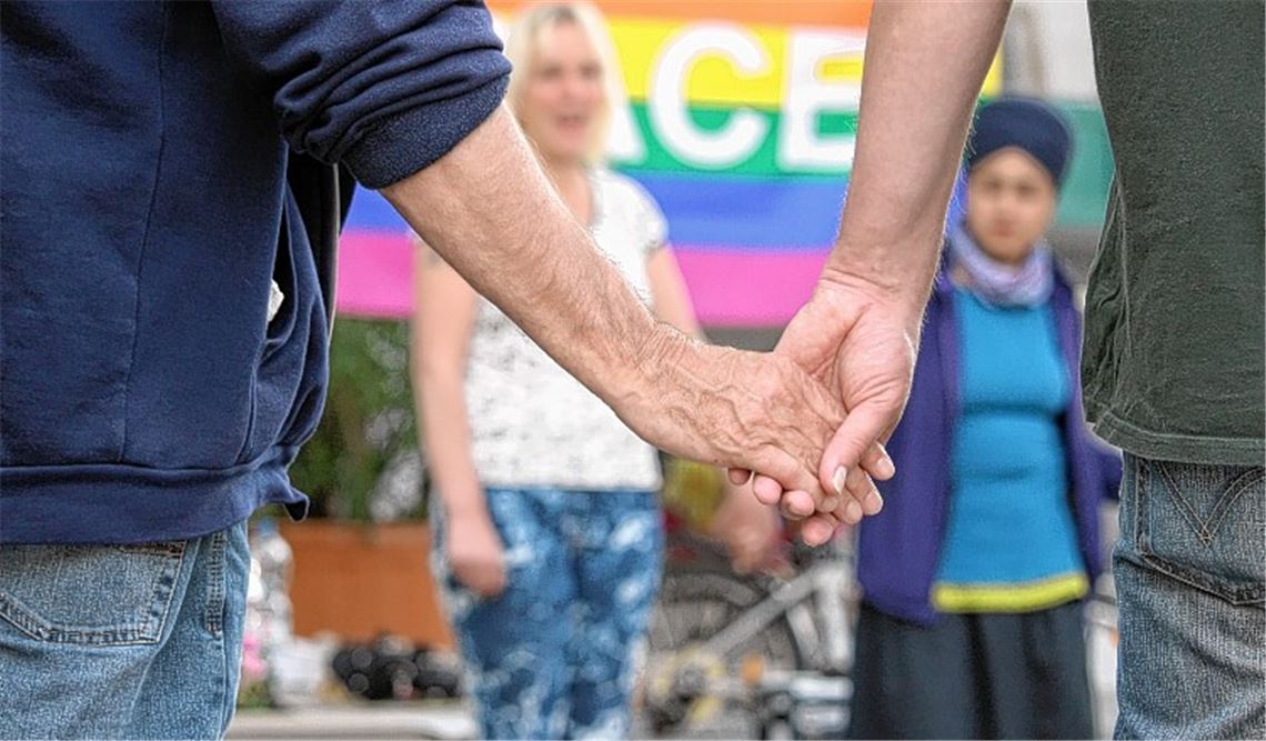 Auf dem Kelterplatz reichen sich etwa 25 Aktivisten für den Frieden die Hände.