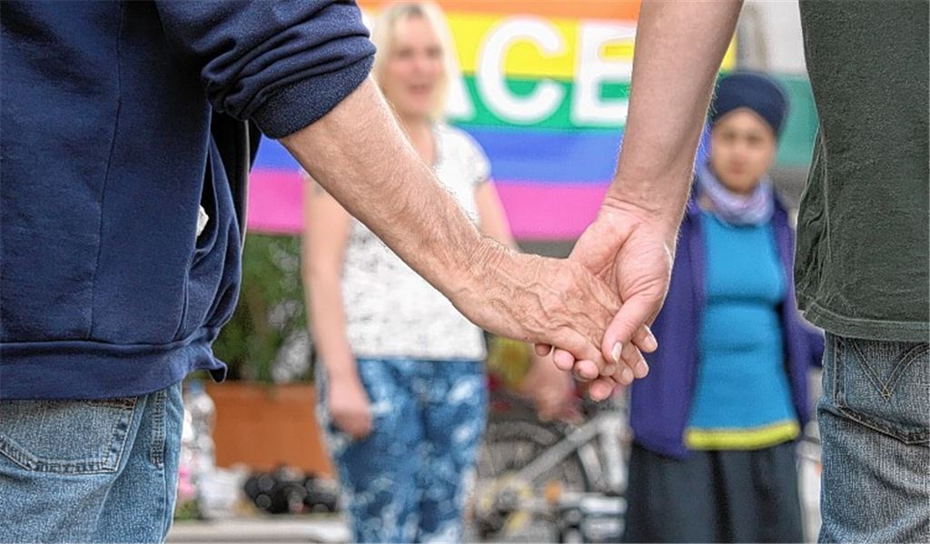 Auf dem Kelterplatz reichen sich etwa 25 Aktivisten für den Frieden die Hände.